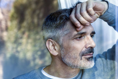 Mature man looking out of window