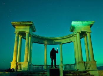 Rear view of man against sky at night