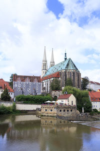 View of buildings in city against cloudy sky