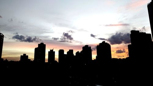 Silhouette buildings against sky during sunset