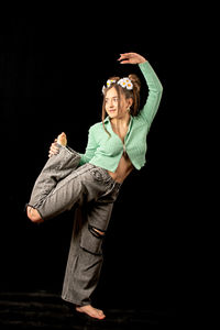 Woman standing against black background