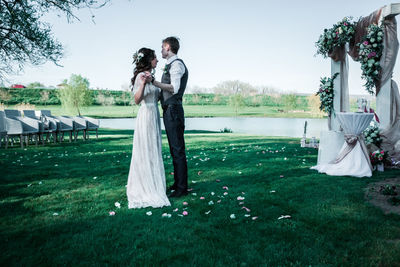 Friends standing on grassy field