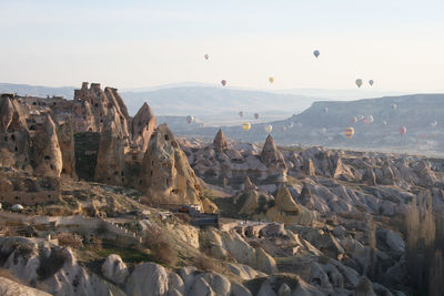View of hot air balloons flying over landscape