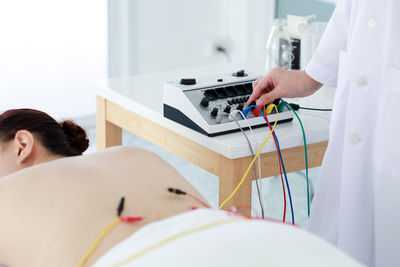 Midsection of woman using mobile phone on table