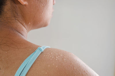 Close-up of shirtless woman against white background