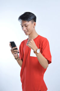 Success winner asian man winning on cellphone app. cheering asian man looking at smartphone online gaming challenge or work deal