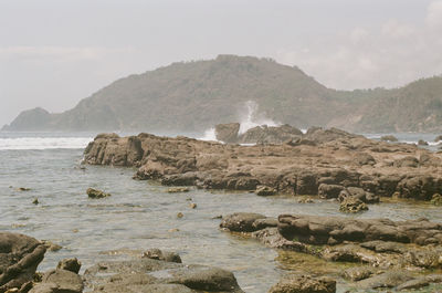 Scenic view of sea and mountains against sky