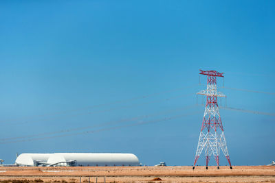 Low angle view of communications tower against clear blue sky