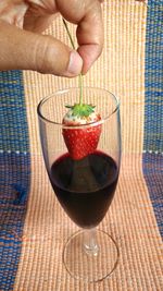 Close-up of woman holding drink served on table