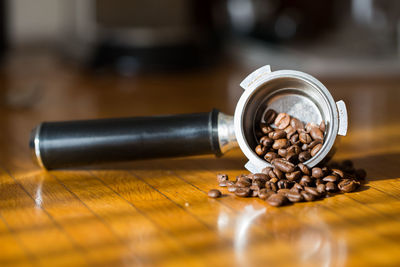 Close-up of coffee beans in portafilter on table