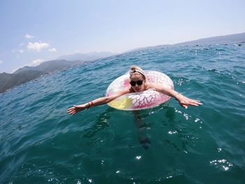 Woman swimming in sea against sky