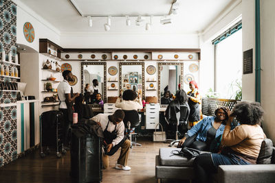 Multiracial barbers and customers in hair salon