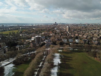 High angle view of city by buildings against sky