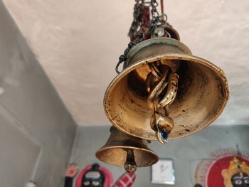 Low angle view of bell hanging against wall