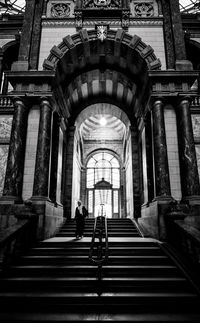 Rear view of people walking on staircase of building