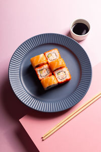 Traditional japanese food philadelphia sushi on a modern pink background, minimalistic concept