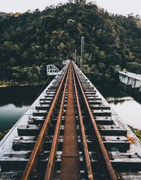 Railroad tracks by trees against sky