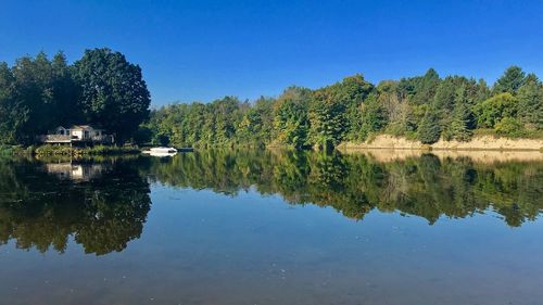 Scenic view of lake against clear blue sky