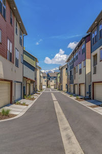 Empty road amidst buildings against sky