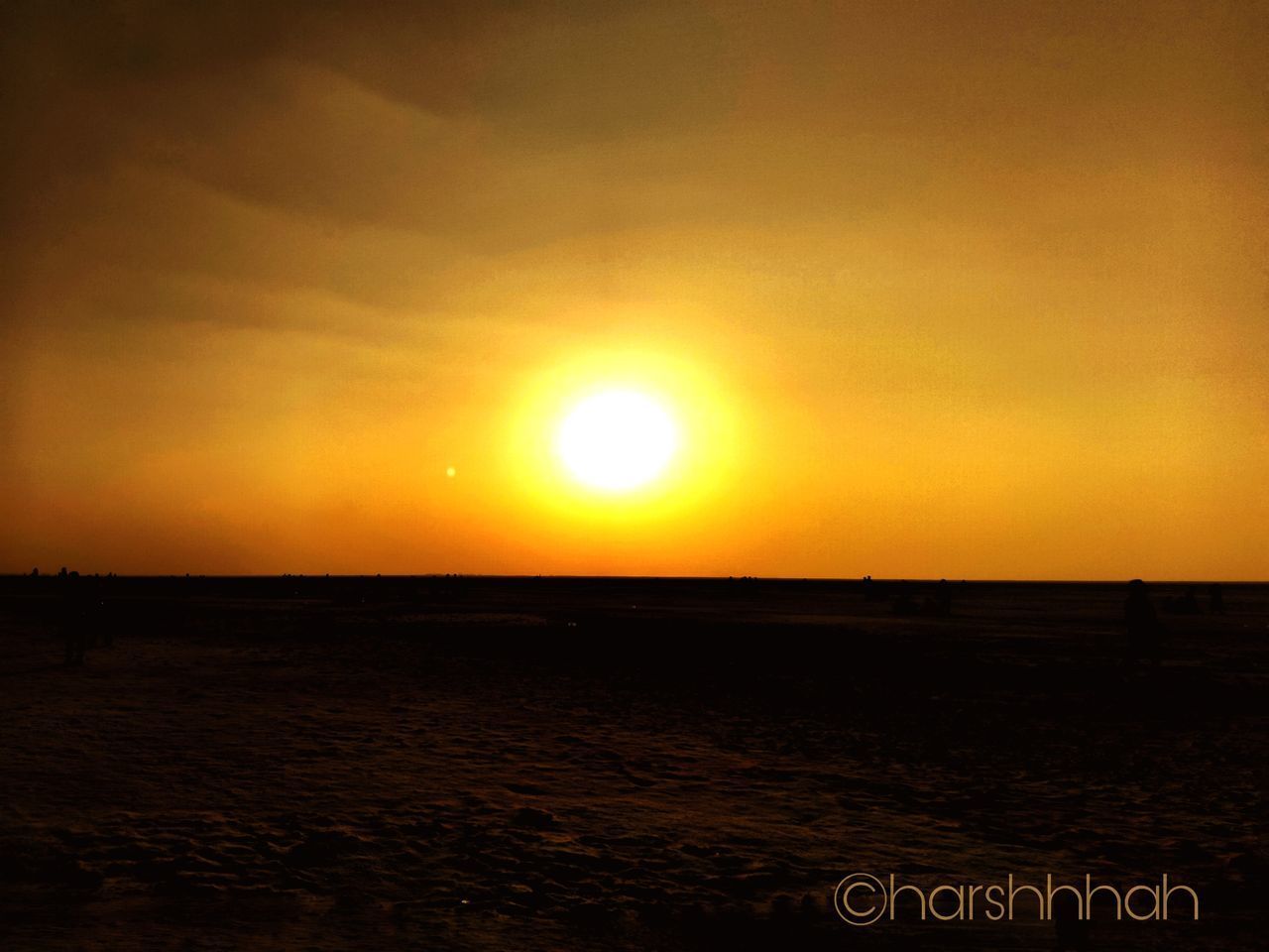 SCENIC VIEW OF BEACH AGAINST ORANGE SKY