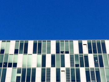 Low angle view of modern building against clear blue sky