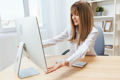 Young businesswoman using laptop at office