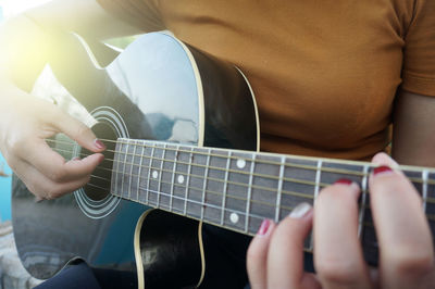 Midsection of man playing guitar