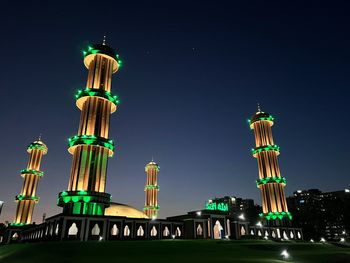 Low angle view of illuminated mosque against sky at night 