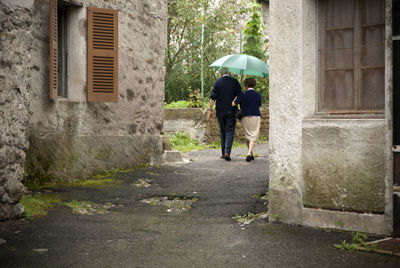 Rear view of people walking in front of building