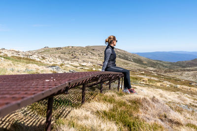 Woman standing on mountain against sky