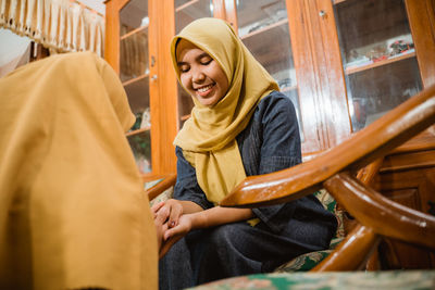 Portrait of young woman sitting on chair