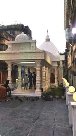 People in front of temple against sky