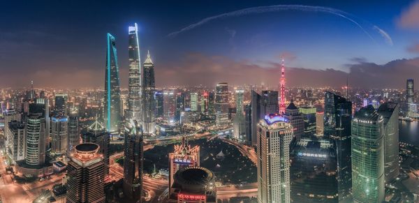 Illuminated cityscape against blue sky