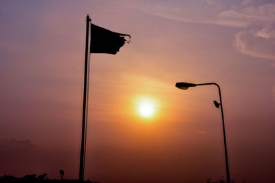 Low angle view of street light against orange sky