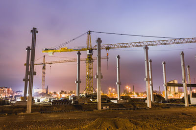 Construction site against sky during sunset