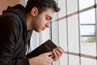 Portrait of young man holding book