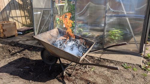 High angle view of fire on barbecue grill in yard