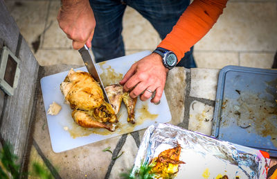 Cropped image of man cutting meat