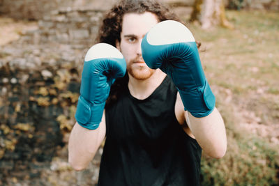 Portrait of man practicing boxing outdoors