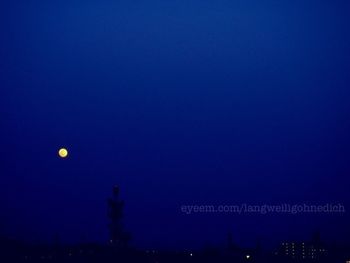 Low angle view of moon in dark sky