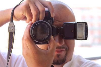 Close-up of man photographing through camera