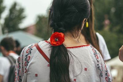 Rear view of woman wearing red flower