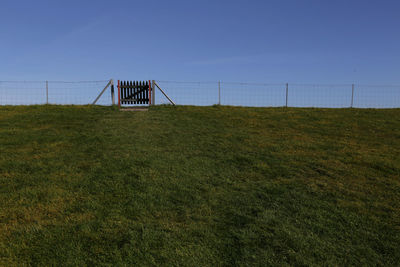 Built structure on grassy field against clear sky