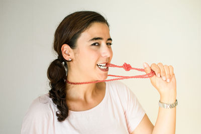 Portrait of a woman eating food over white background