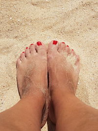 Low section of woman on sand