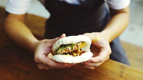 Cropped image of man holding burger