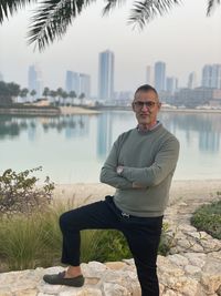 Portrait of man standing by water overlooking the water in bahrain abate.