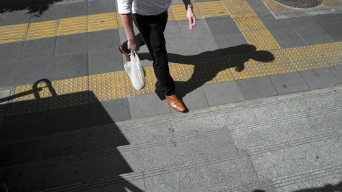 Low section of people walking on street