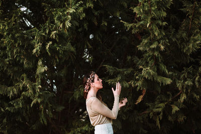 Midsection of woman photographing by tree