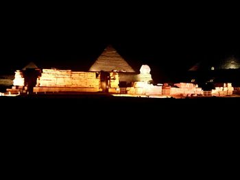 Illuminated building against clear sky at night